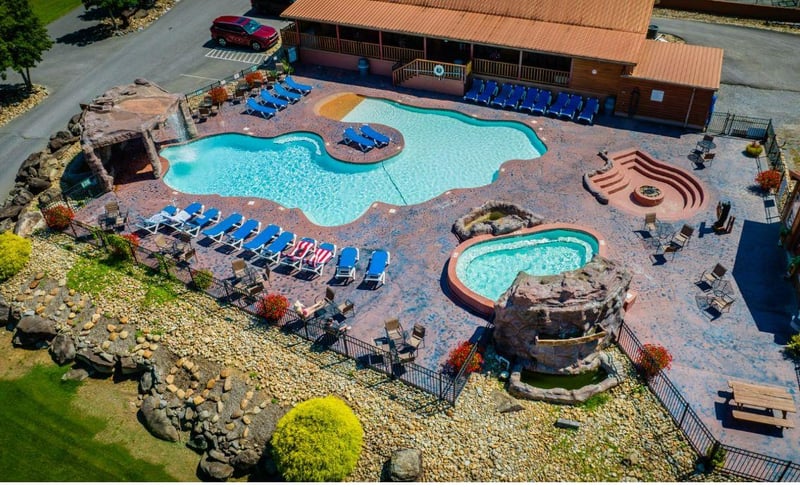 Aerial view of the resorts pool complex featuring a main swimming pool, hot tub, and recreational facilities.