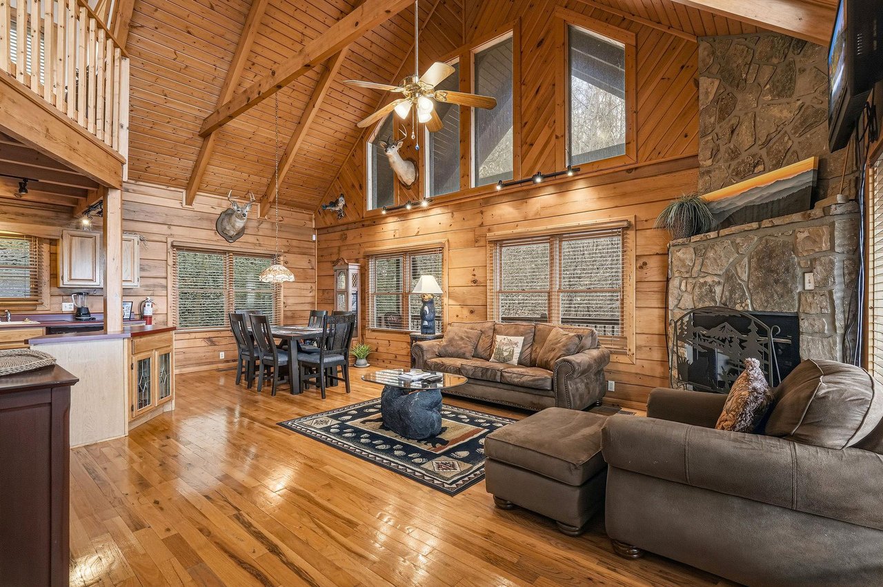 Relax in your spacious log cabin retreat, where warm wood surrounds you and a crackling stone fireplace creates the perfect mountain getaway atmosphere.