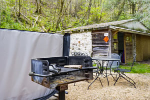 Fire up the grill for an unforgettable outdoor feast Your private BBQ area awaits with dining table surrounded by peaceful woodland.