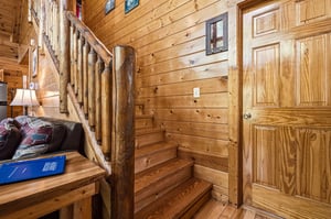 Step into rustic charm with handhewn log railings and warm pine walls that create a cozy mountain retreat atmosphere throughout your stay.