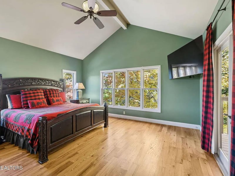 Your serene bedroom features vaulted ceilings, natural light streaming through large windows, and a ceiling fan to keep you comfortable. Step through the balcony door to enjoy leafy views and fresh ai