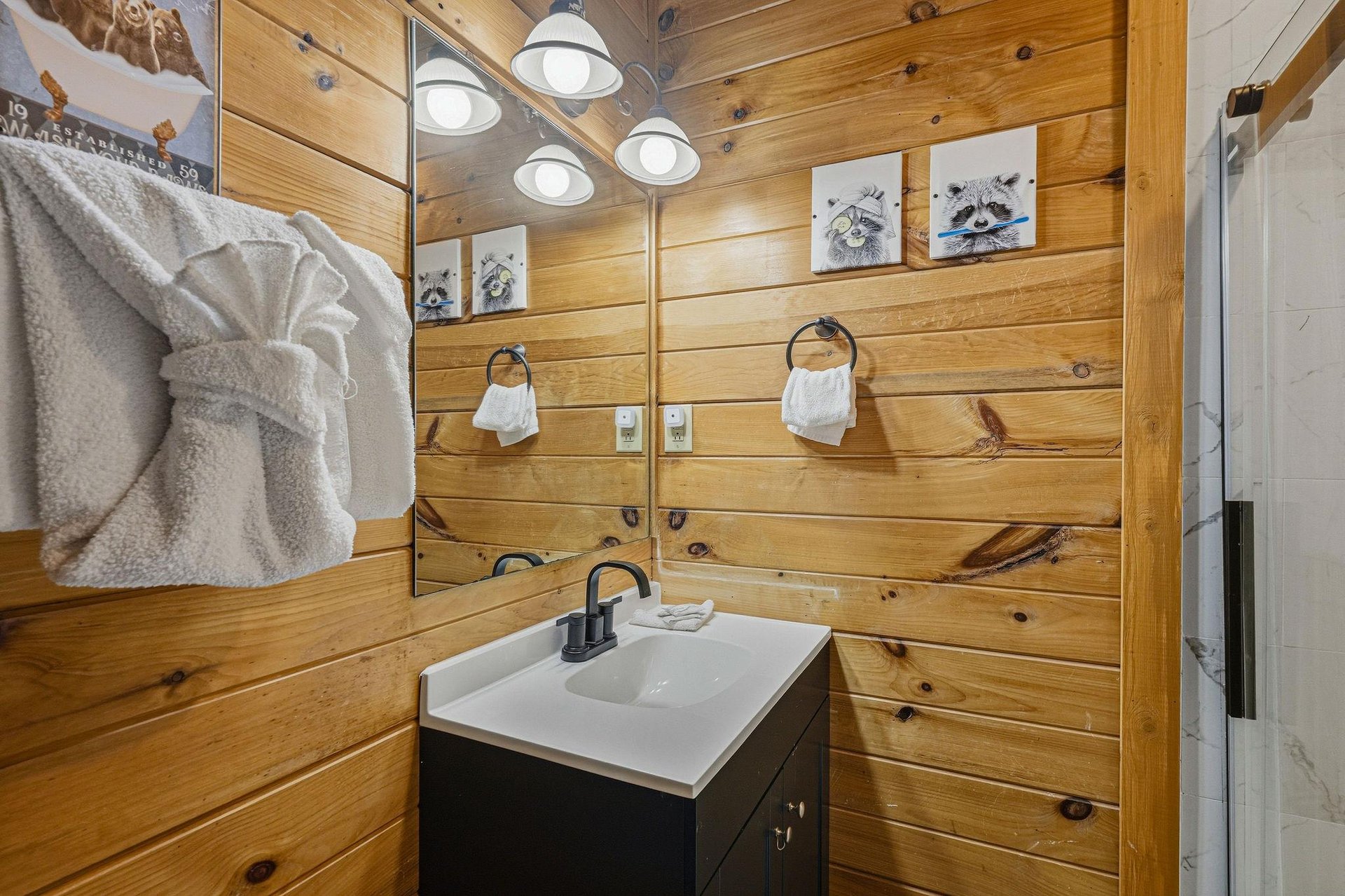 Step into your cozy bathroom featuring warm wood walls, modern fixtures, and charming woodland decor that makes freshening up feel like a cabin retreat.
