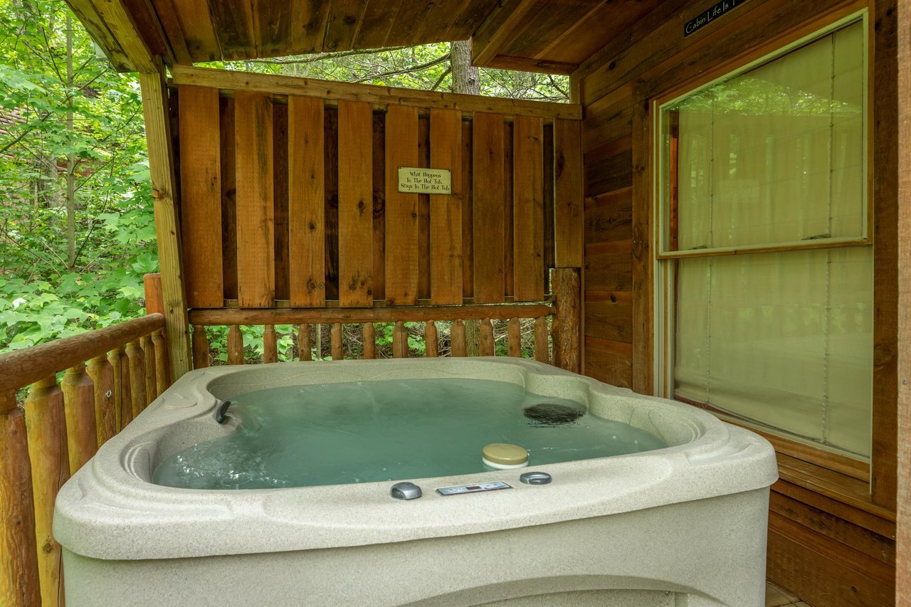Hot tub and privacy fence on the deck at Logans Smoky Den, a 2 bedroom cabin rental located in Pigeon Forge