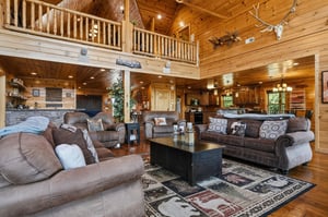 Step into your spacious retreat with vaulted ceilings, rustic wood beams, and plush seating that invites you to unwind. The open layout connects your cozy living area with a full kitchen, perfect for 