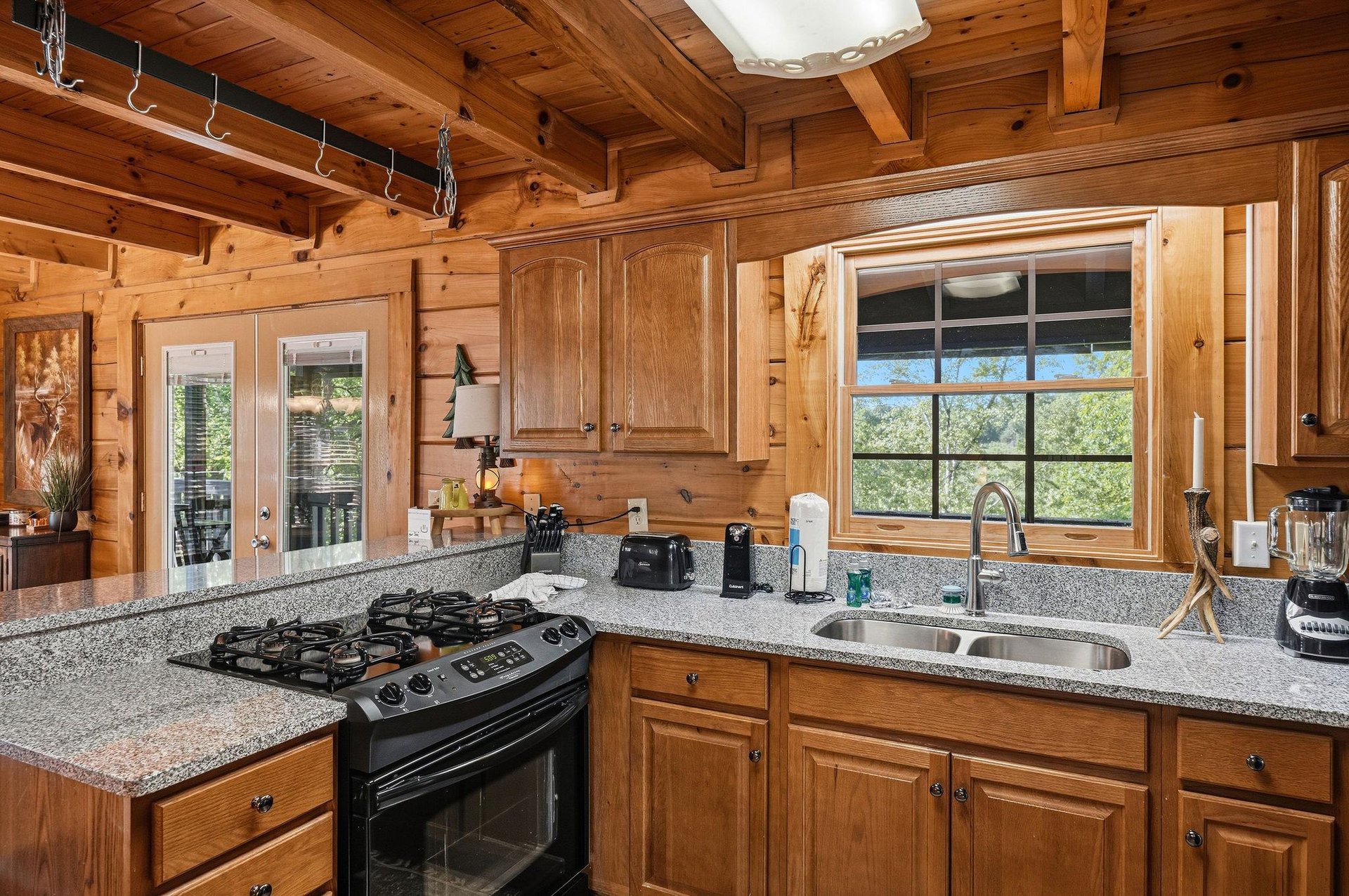 Cook your favorite meals in this fully equipped cabin kitchen with granite counters, gas stove, and forest views right outside your window.
