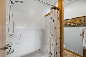 Fresh, clean bathroom with charming pine tree curtains and rustic wood touches for your mountain retreat comfort.