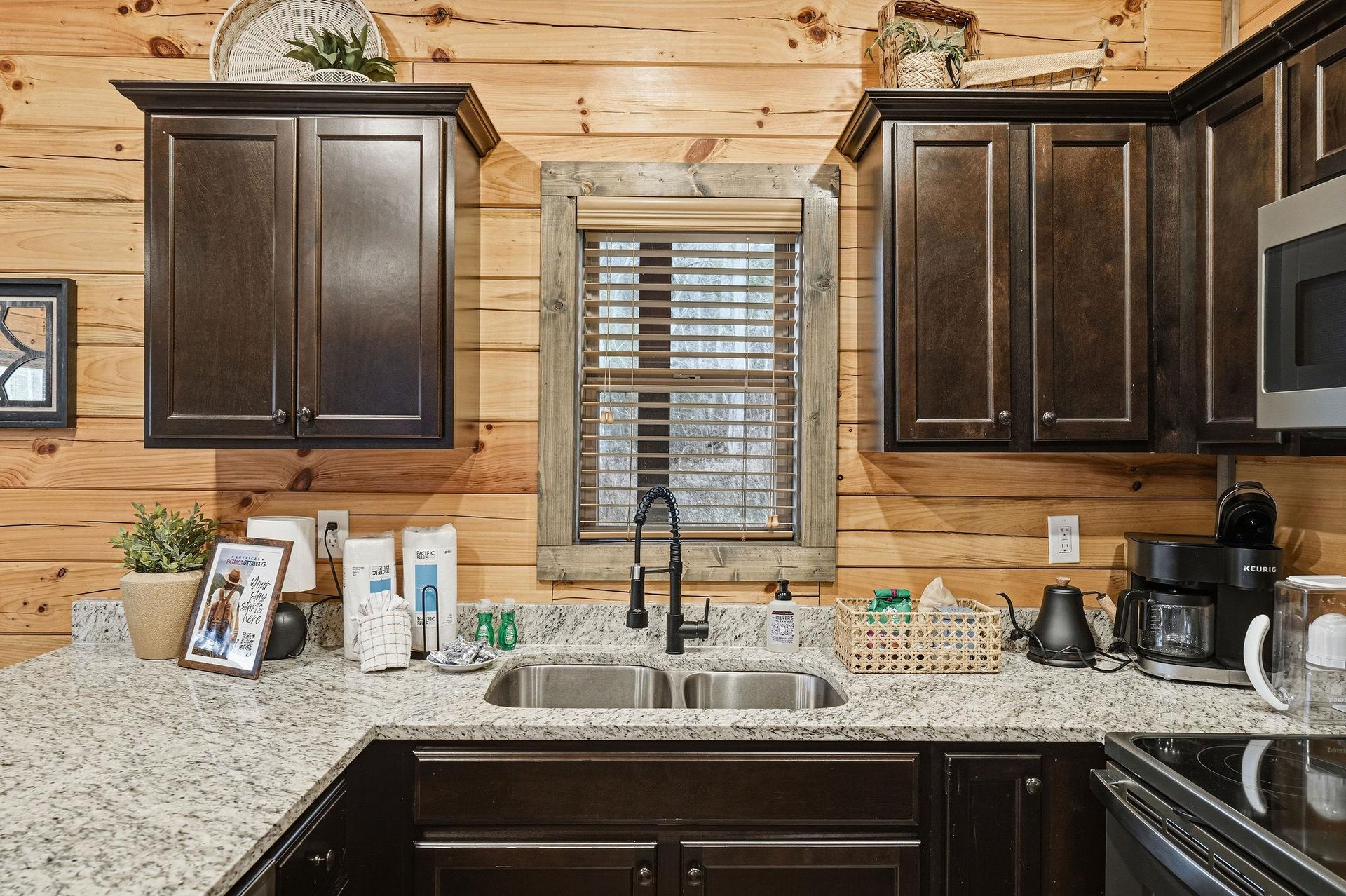 Your fully equipped kitchen features granite counters, dark wood cabinets, and modern appliances for preparing memorable meals together.