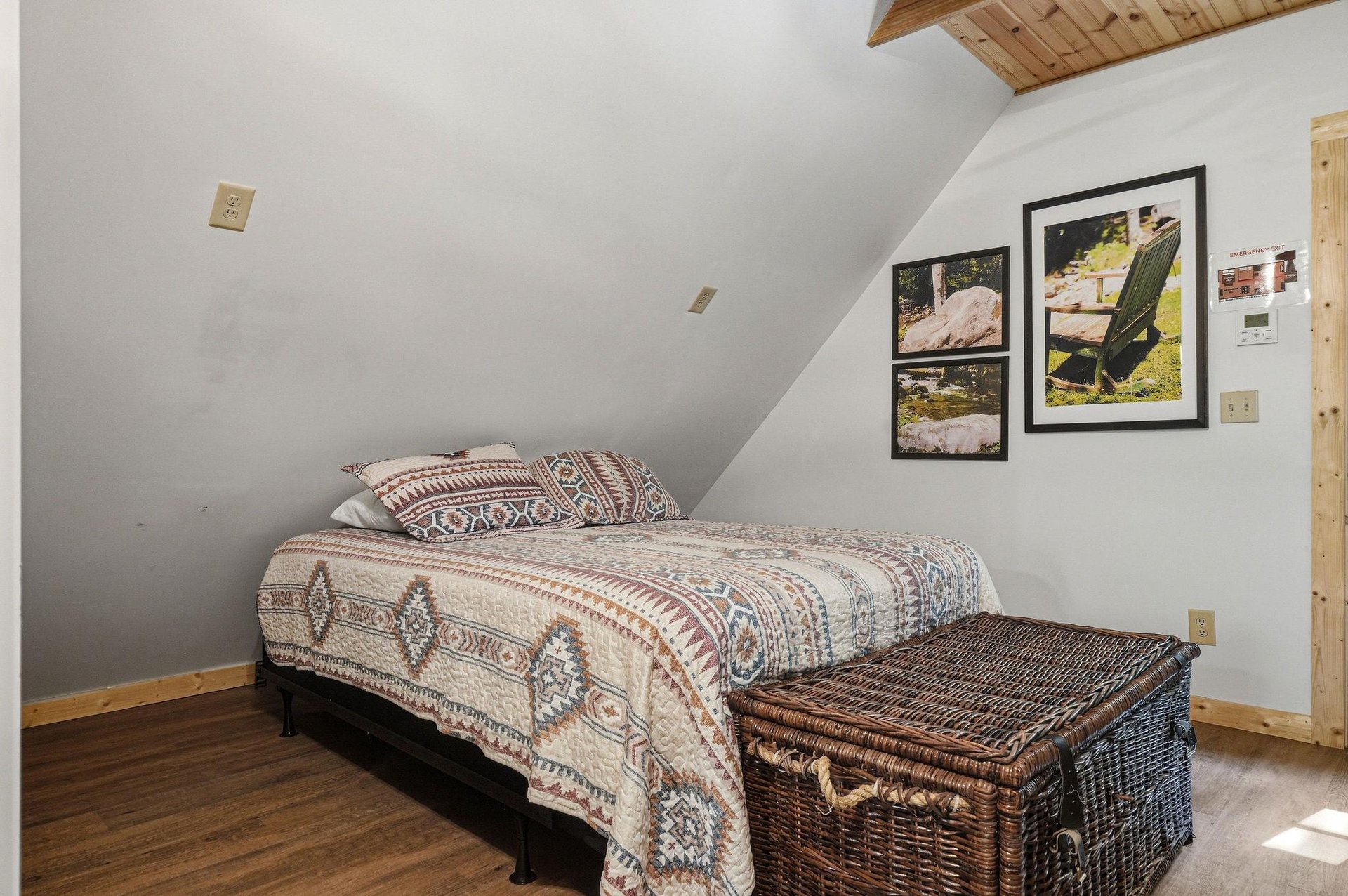 Unwind in your cozy loft bedroom with its vaulted wood ceiling, plush bedding, and charming framed art inviting restful mountain dreams.