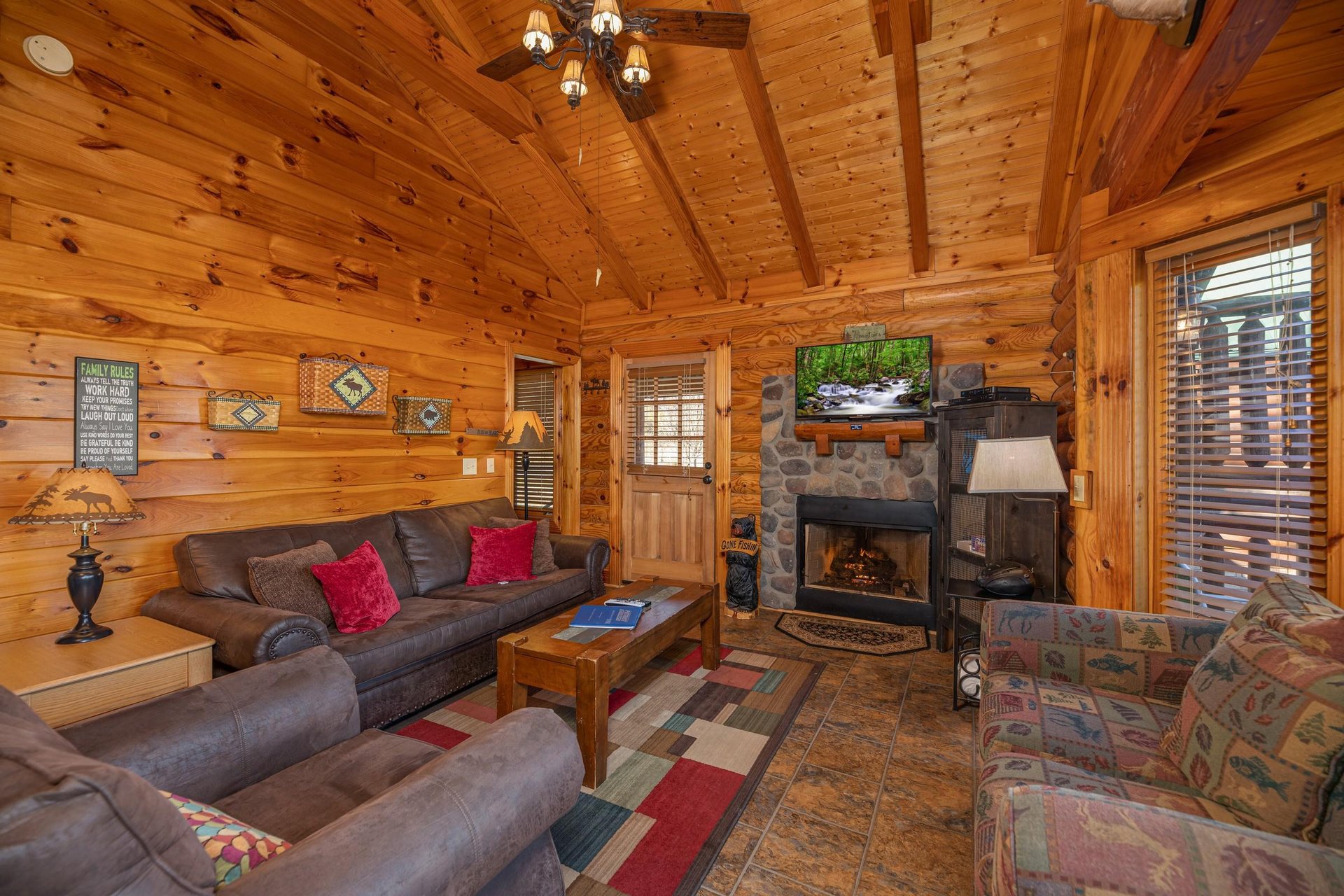 Fireplace, tv, and furniture in the living room at Gone Fishin, a 2bedroom cabin rental located in Pigeon Forge