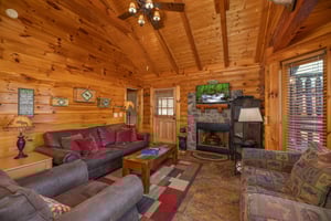 Fireplace, tv, and furniture in the living room at Gone Fishin, a 2bedroom cabin rental located in Pigeon Forge