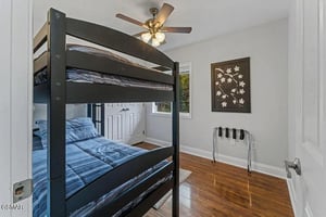 Your comfortable bedroom features stylish bunk beds with cozy blue linens and a peaceful ceiling fan for restful nights.
