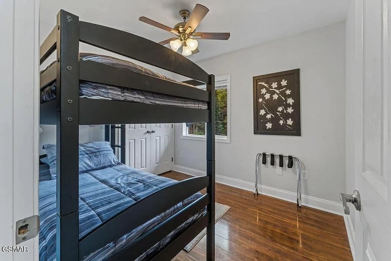 Your comfortable bedroom features stylish bunk beds with cozy blue linens and a peaceful ceiling fan for restful nights.