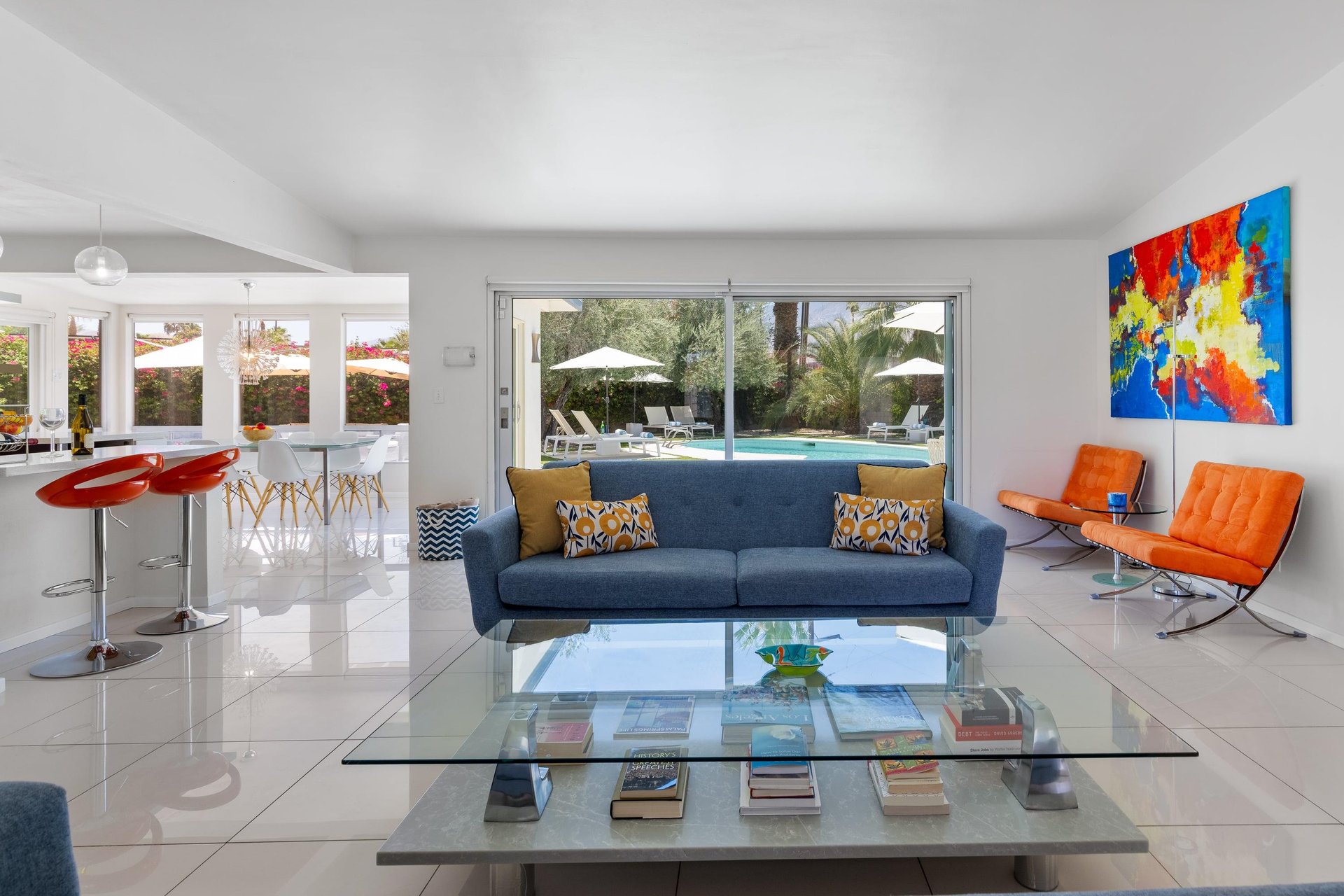 Living room with couch seating, fireplace, pool views, and openconcept living space.