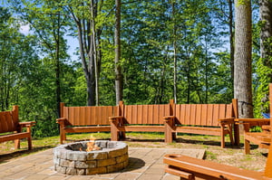 Gather around your private fire pit surrounded by comfortable wooden seating, where forest views create the perfect backdrop for evening conversations.