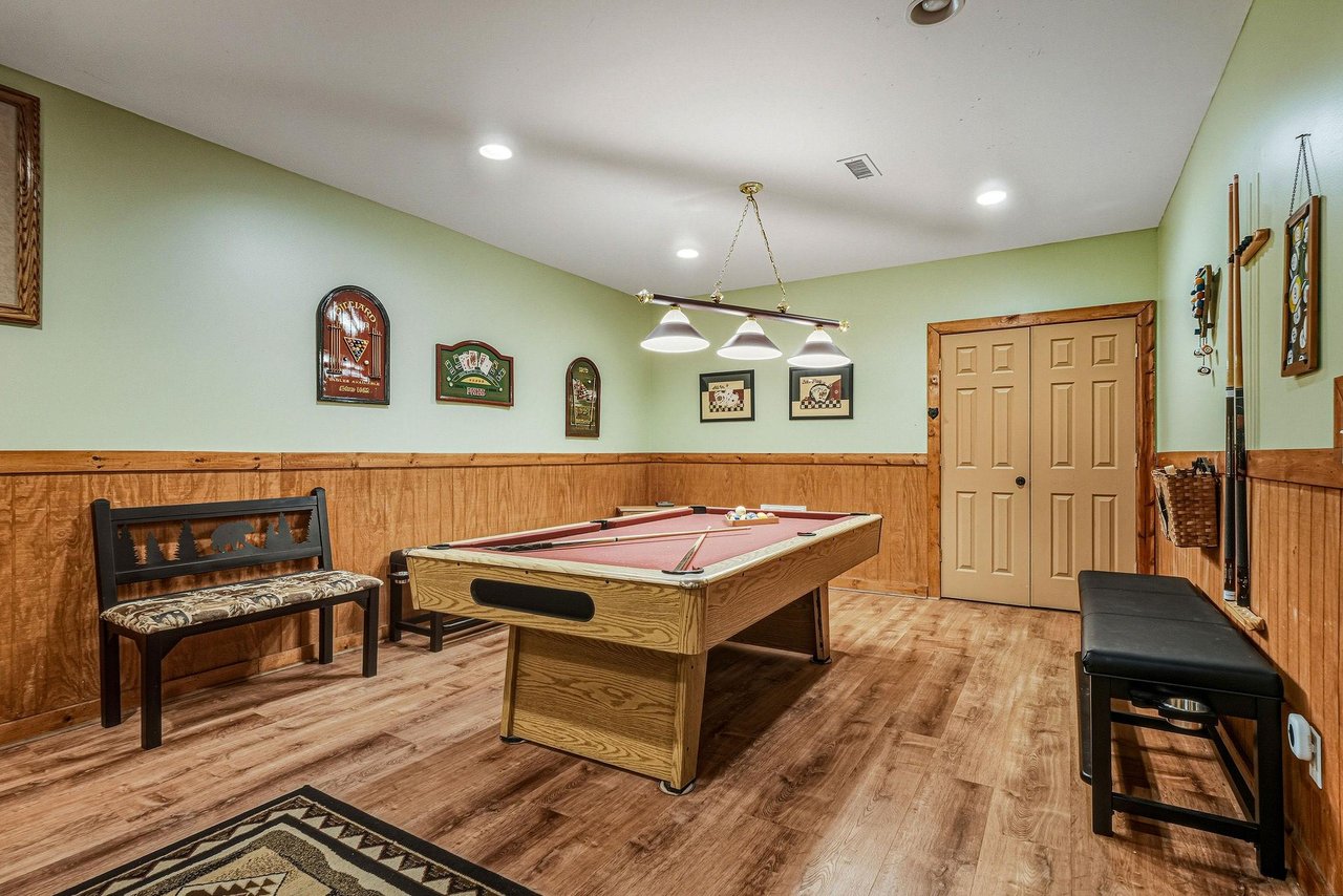 Challenge friends to a game in your private billiards room, complete with rustic wood paneling and cozy seating for spectators.