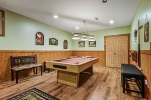 Challenge friends to a game in your private billiards room, complete with rustic wood paneling and cozy seating for spectators.