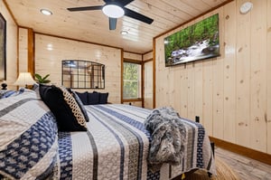 Curl up in this cozy bedroom where natural wood tones and soft linens create a warm, cabininspired escape just for you.