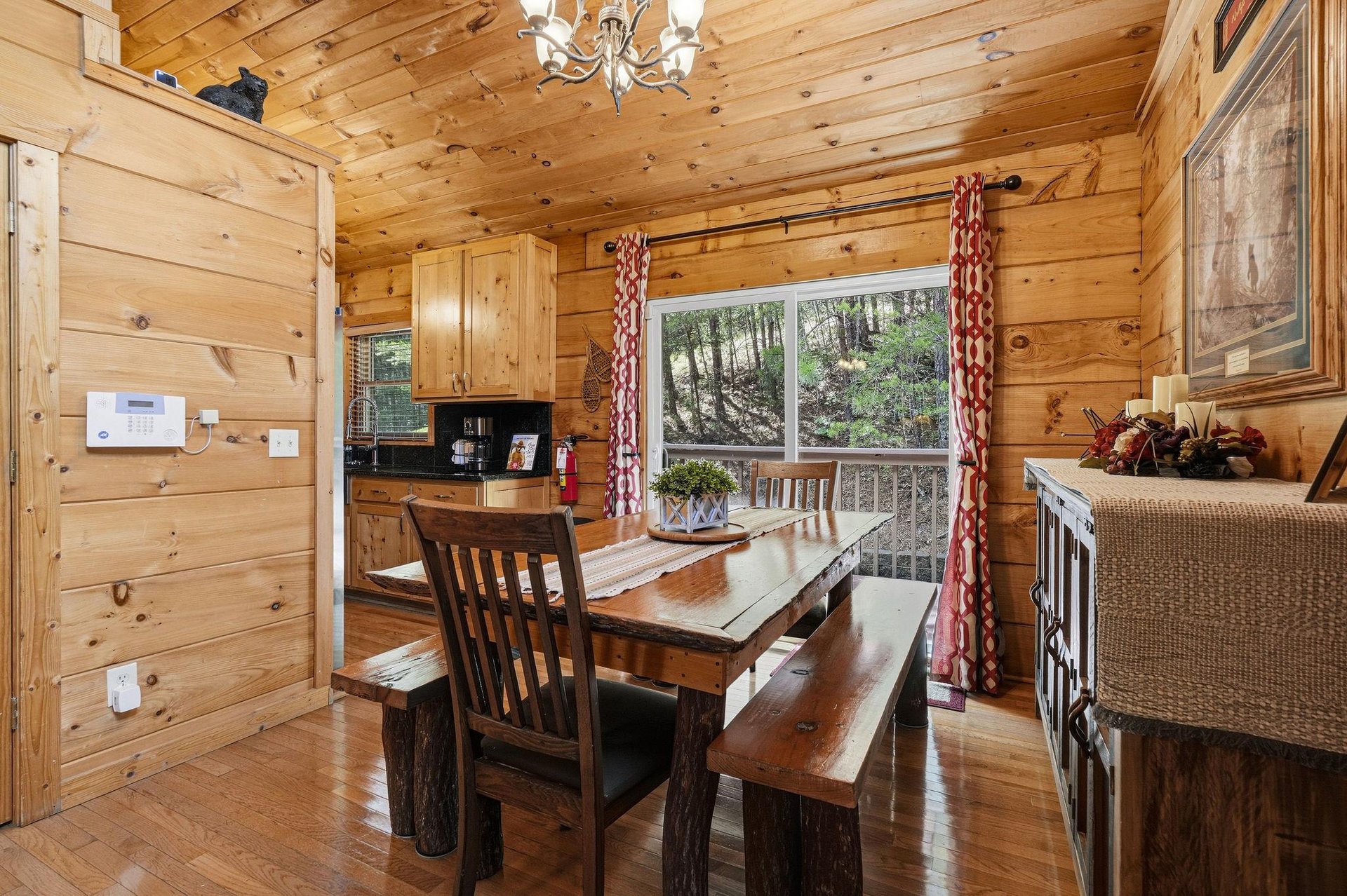 Gather around this handcrafted rustic dining table where your mornings start with forest views through the picture window, and evenings linger over homecooked meals in the warm glow of the antler cha