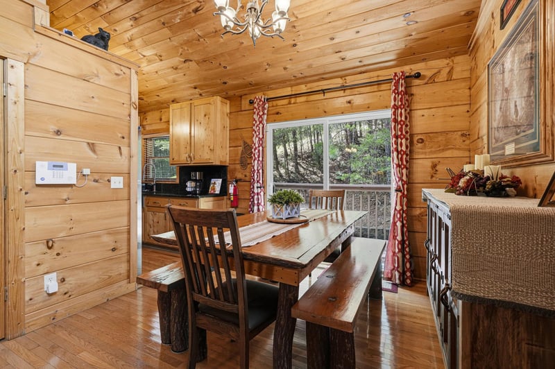 Gather around this handcrafted rustic dining table where your mornings start with forest views through the picture window, and evenings linger over homecooked meals in the warm glow of the antler cha