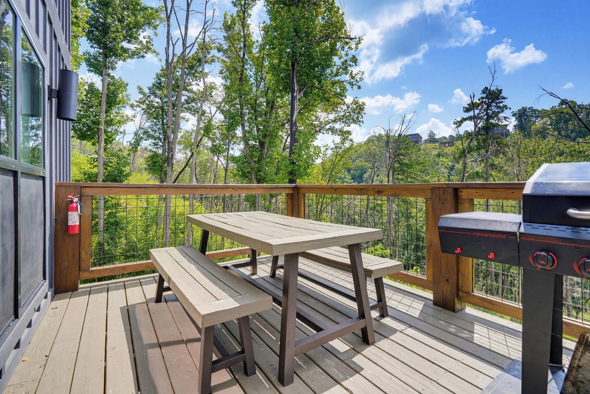 Your private deck invites alfresco dining with a picnic table, grill, and serene woodland views stretching into the distance.