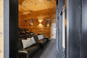 Sink into plush recliners and let the stress melt away in your private theater room with warm wood walls and soft lighting—perfect for movie nights.