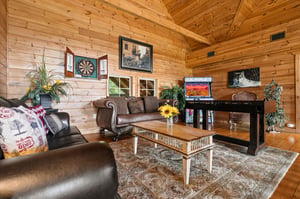 Unwind in this inviting cabinstyle living room with vaulted wood ceilings, cozy leather seating, and rustic touches that make you feel right at home.