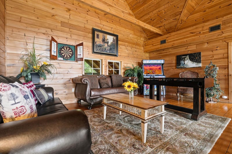 Unwind in this inviting cabinstyle living room with vaulted wood ceilings, cozy leather seating, and rustic touches that make you feel right at home.