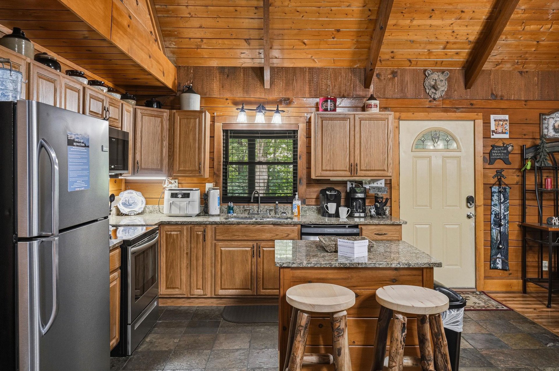 Step into your fully equipped cabin kitchen, where rich wood details and granite countertops set the stage for homecooked meals. The cozy space blends rustic charm with modern appliances, making it e