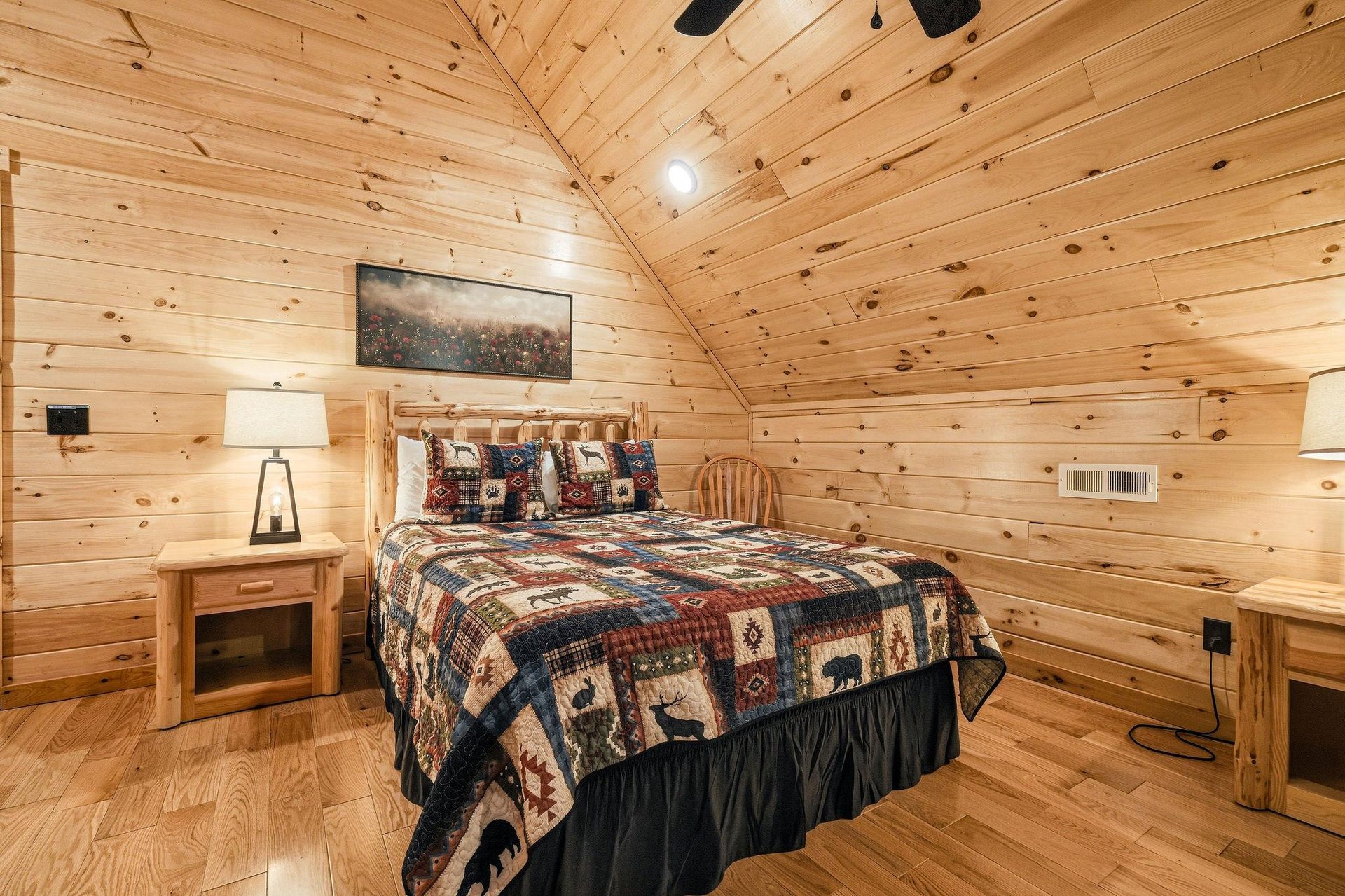 Escape to your cozy cabin bedroom where rustic wood walls and charming wildlife quilts create the perfect mountain retreat atmosphere.