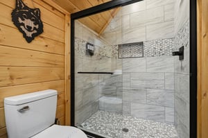 Step into your luxurious walkin shower featuring stunning marblelook tiles and modern fixtures in this rusticchic bathroom retreat.
