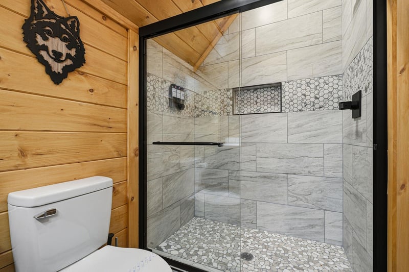 Step into your luxurious walkin shower featuring stunning marblelook tiles and modern fixtures in this rusticchic bathroom retreat.