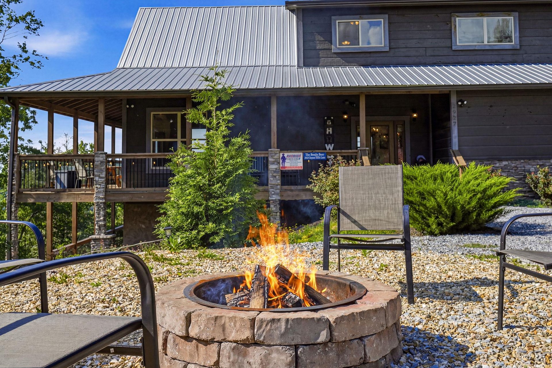 The stone fire pit provides a cozy gathering spot, with comfortable seating and the propertys welcoming exterior in the background.