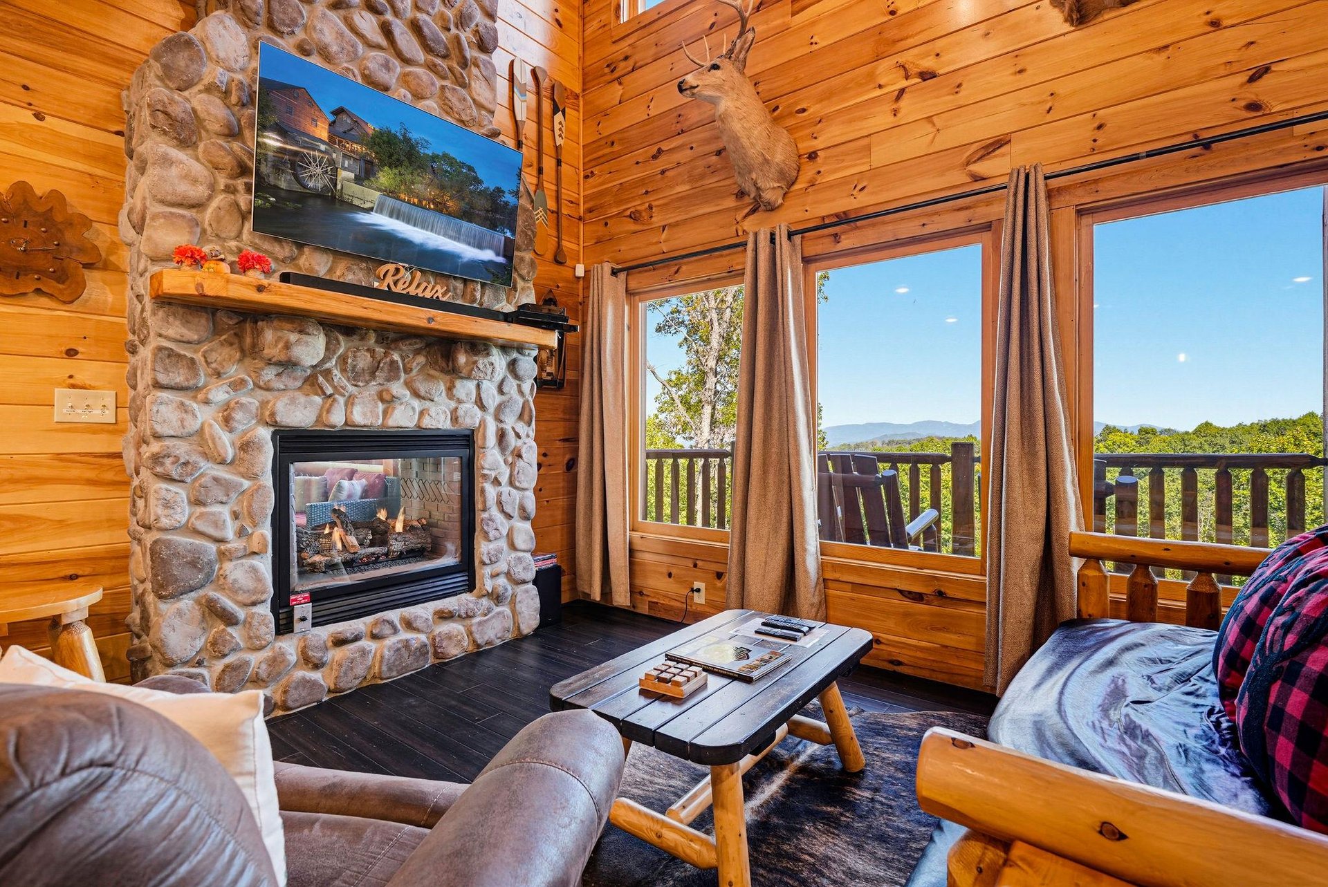Step into rustic warmth and breathtaking vistas. Floortoceiling windows frame mountain views while a stone fireplace invites cozy evenings in your private retreat.