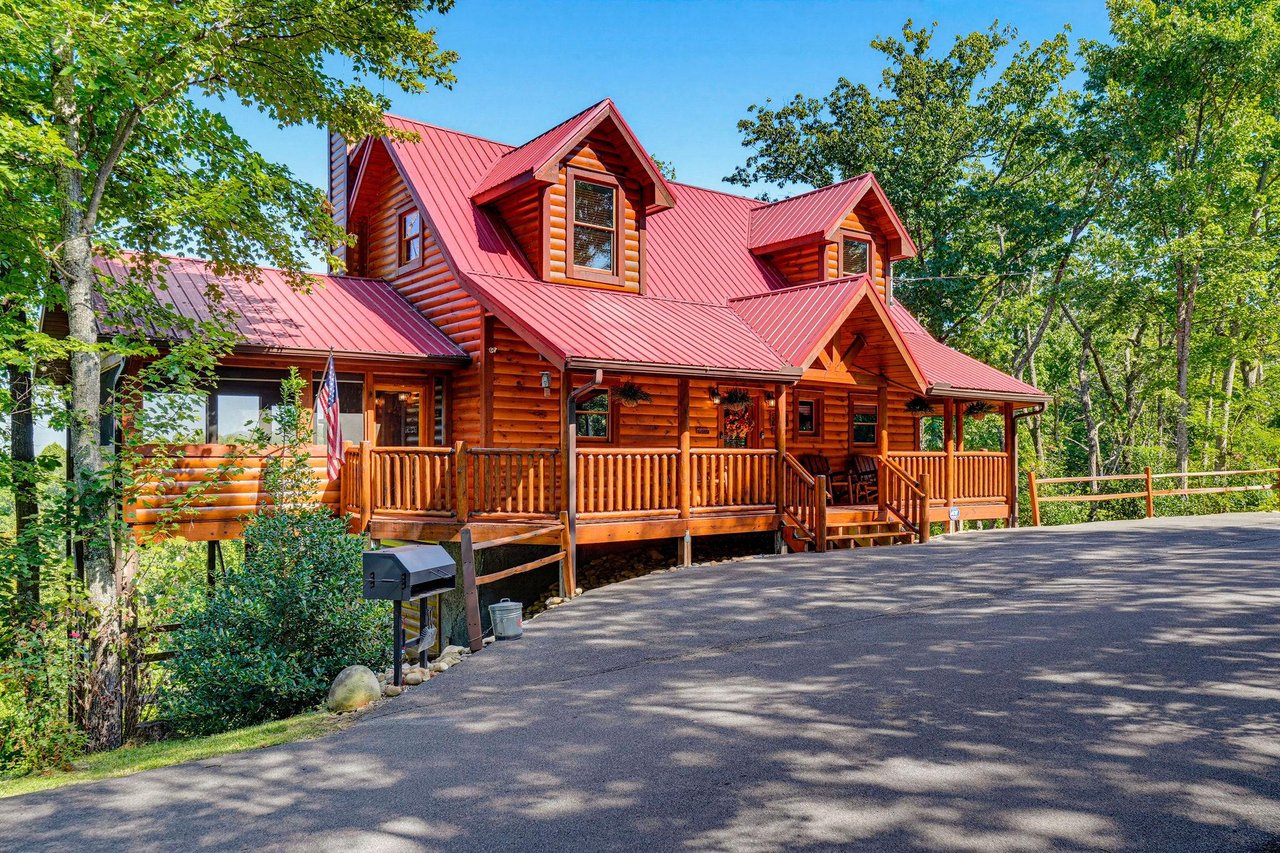 Nestled among lush green trees, this charming log cabin with its welcoming front porch and spacious parking area offers a peaceful mountain retreat.