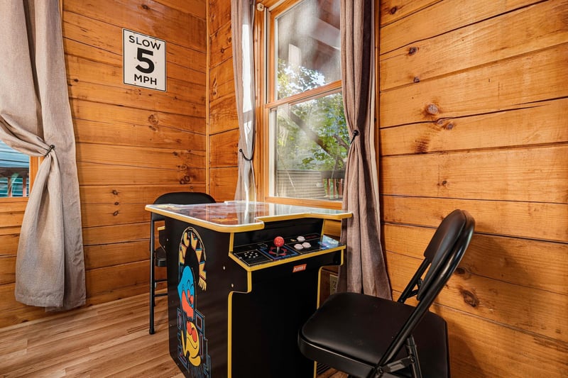 Challenge a friend to a game on the vintage arcade machine, tucked in a cozy spot with warm wood walls and natural light.