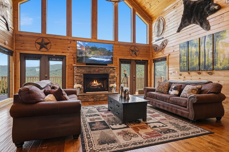 Sink into plush leather sofas in this lightfilled cabin, where soaring windows frame stunning mountain views and a crackling fireplace warms your cozy retreat.