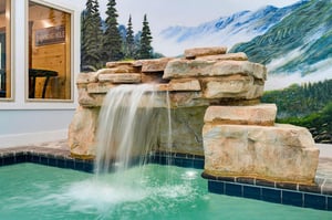 Slip into warm, soothing waters beneath your private stone waterfall—your personal mountain oasis awaits.