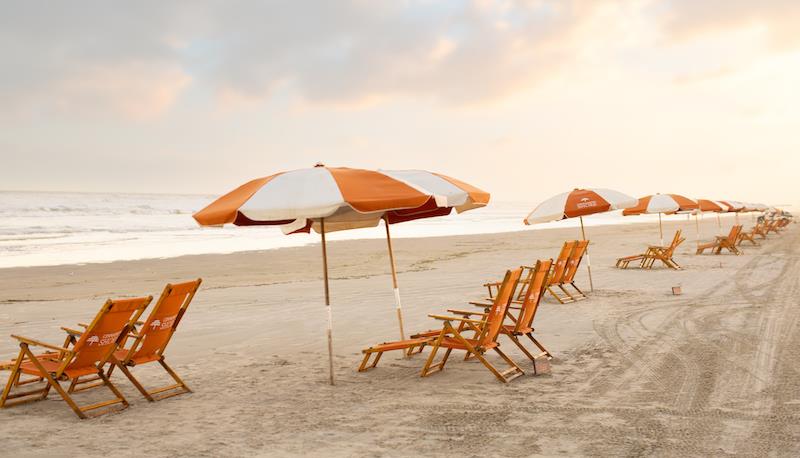 Cinnamon Shore beach chairs and umbrellas set up along the Gulf