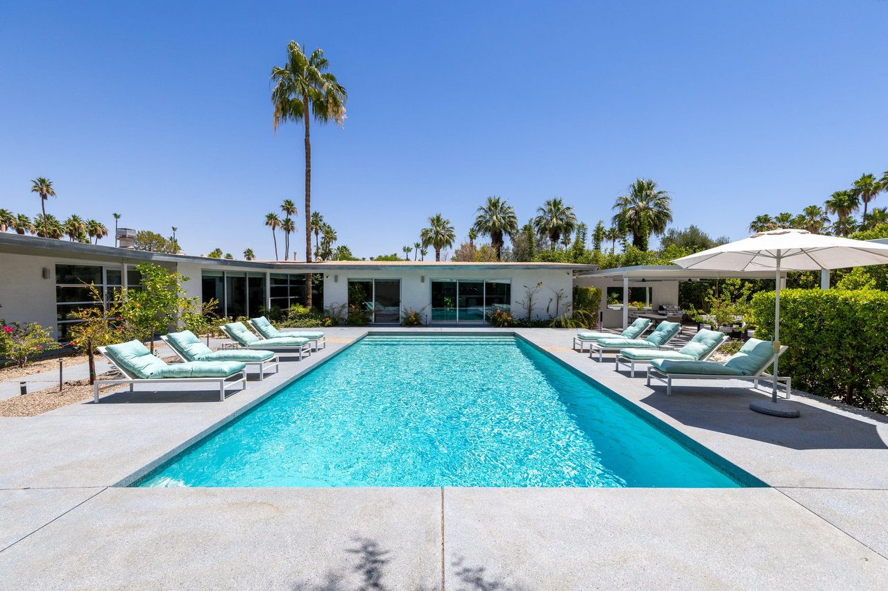 Private poolspa with sun loungers and umbrellas.