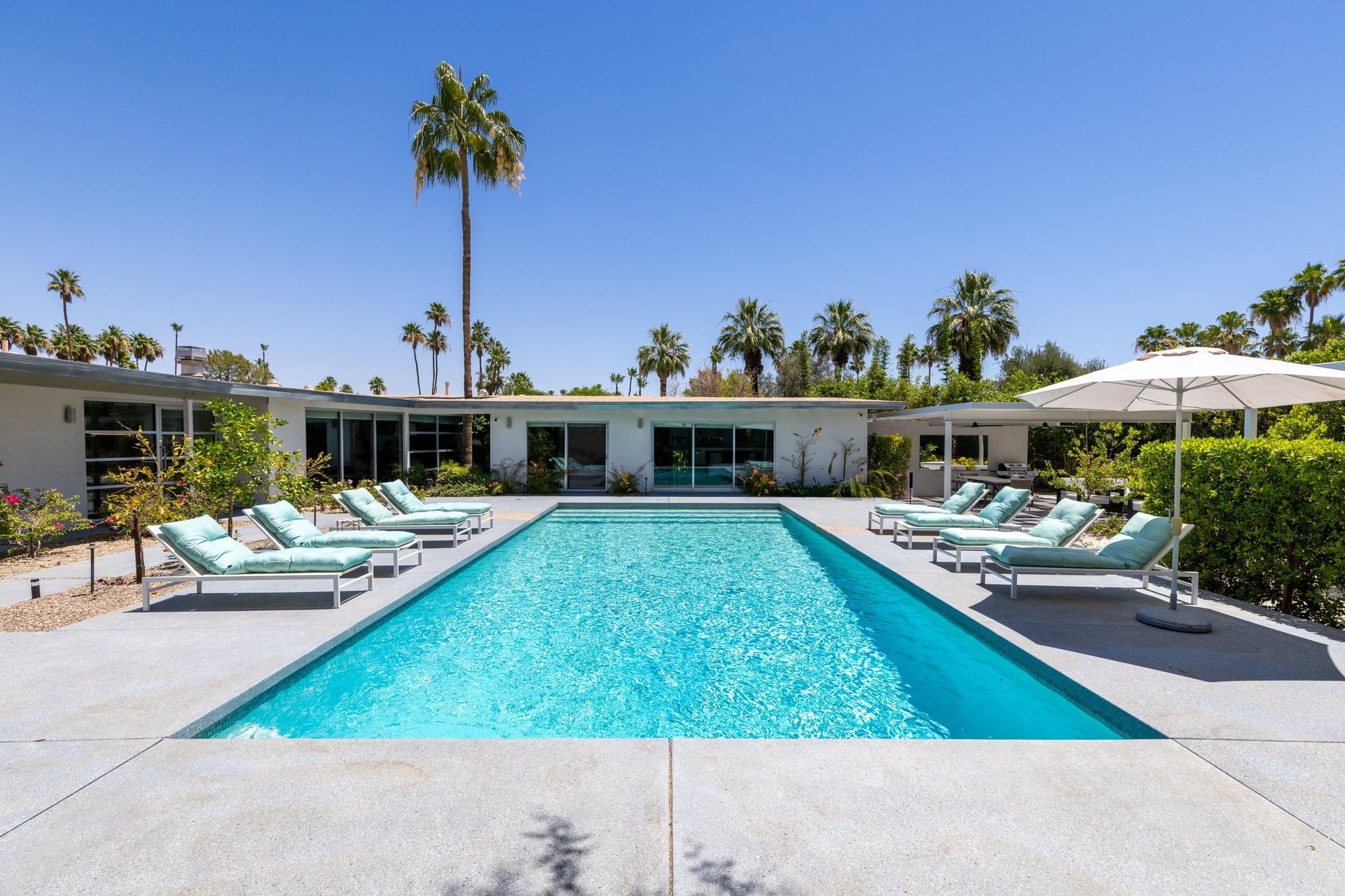 Private poolspa with sun loungers and umbrellas.