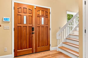 Beautiful double doors and warm hardwood floors greet you as you step into this welcoming space, with a charming staircase inviting you upstairs.