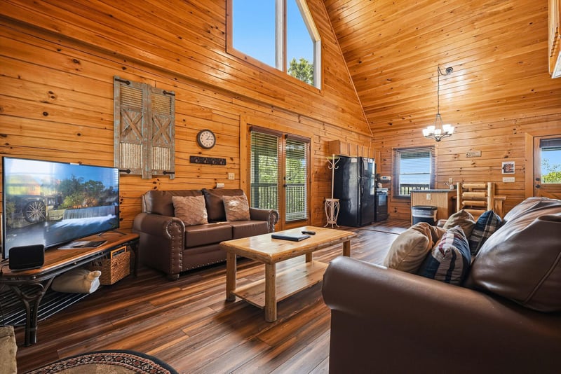 Sink into plush leather sofas beneath soaring wood ceilings. Natural light floods through tall windows while you enjoy your favorite shows on the big screen. Warm wood surrounds you, creating your coz