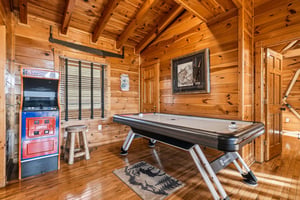 Step into your private game room with soaring woodbeamed ceilings, where friendly competition awaits at the air hockey table or vintage arcade machine—perfect for family fun and making memories toget
