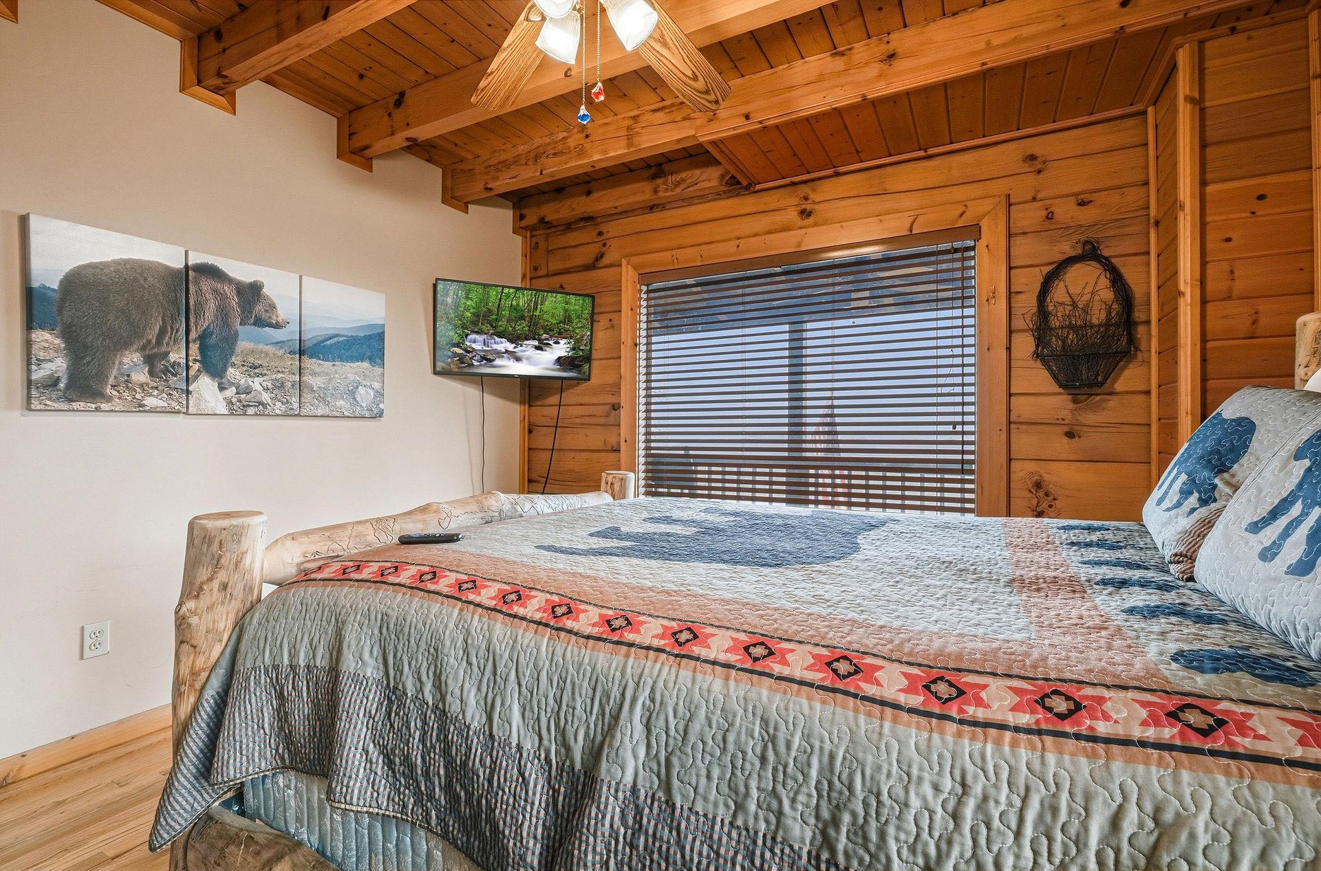 Drift off under dramatic exposed beams in your rustic bedroom, where wildlife art and mountain views create the perfect wilderness retreat.