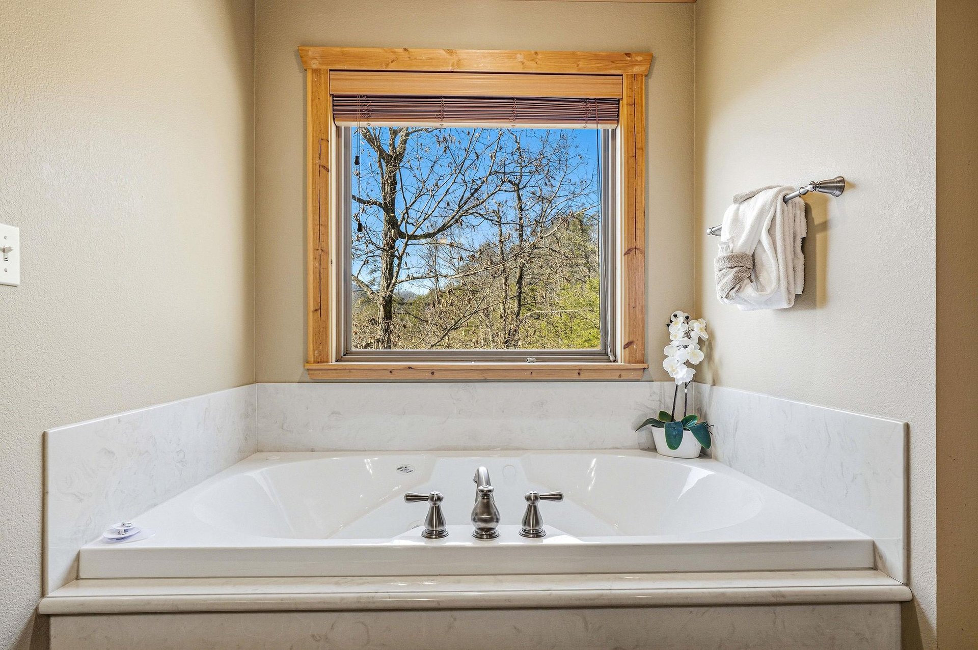 Soak in your private tub while gazing at mountain views through the rustic woodframed window—pure tranquility awaits.
