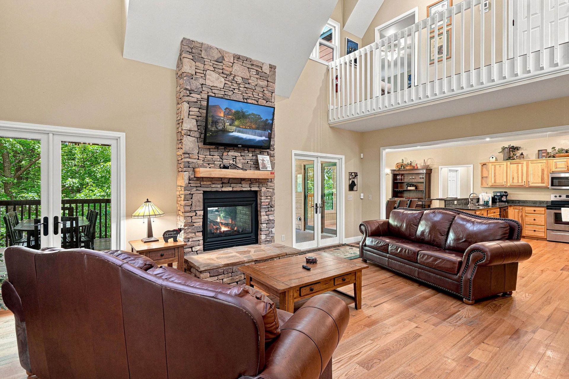 Unwind in your spacious great room featuring soaring ceilings, a stone fireplace, and open views to the kitchen—perfect for gathering with loved ones after a day of mountain adventures.