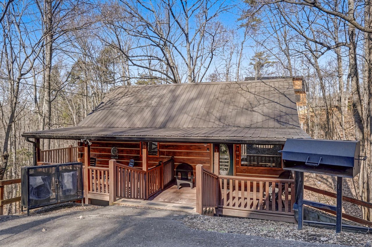 This charming log cabin offers a peaceful woodland retreat with inviting covered decks and natural surroundings for your mountain getaway.
