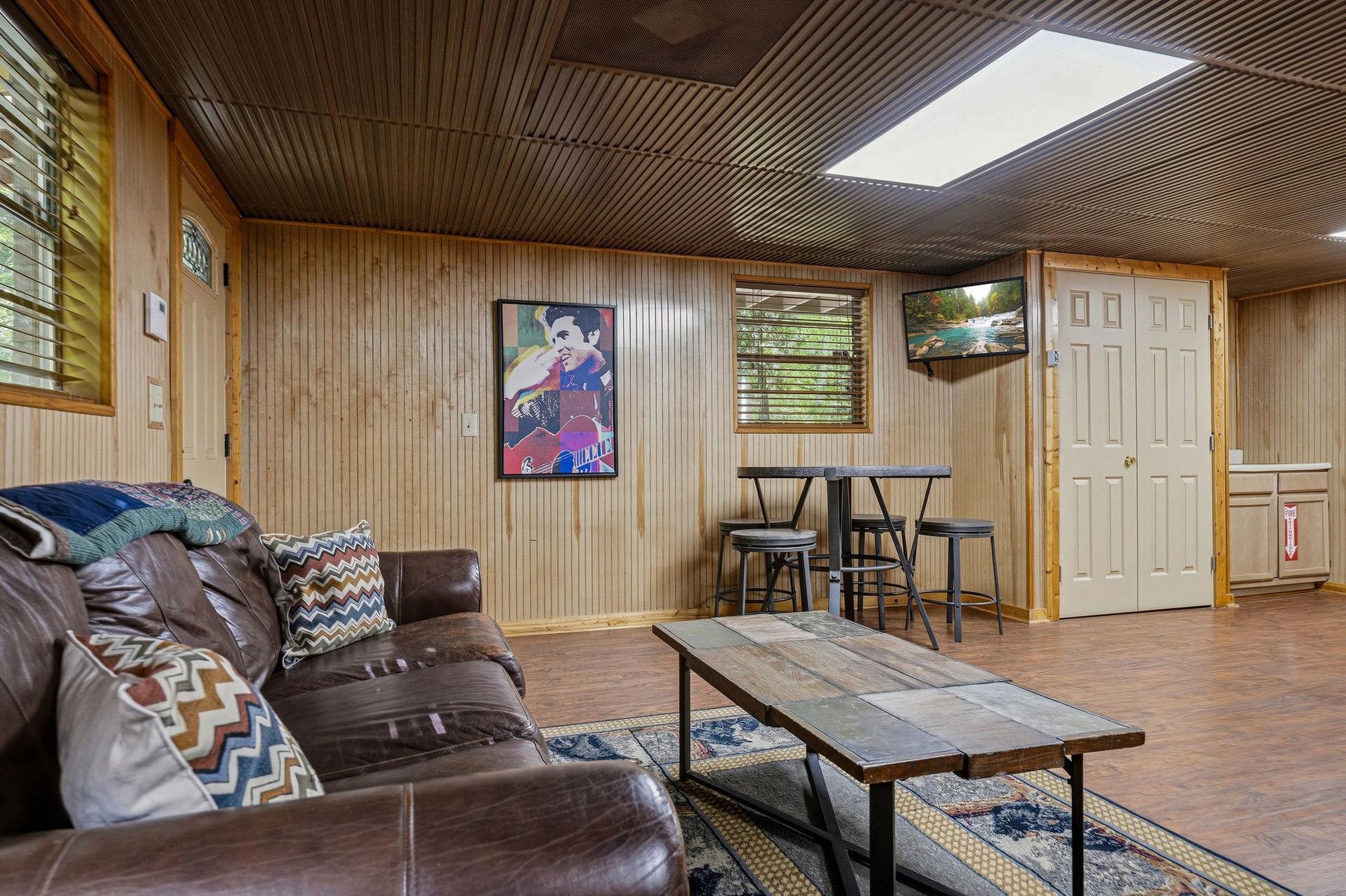 Settle into the cozy leather seating and enjoy your downtime in this inviting retreat, where warm wood tones and natural light create the perfect backdrop for relaxation.