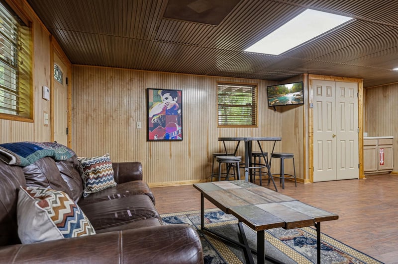 Settle into the cozy leather seating and enjoy your downtime in this inviting retreat, where warm wood tones and natural light create the perfect backdrop for relaxation.
