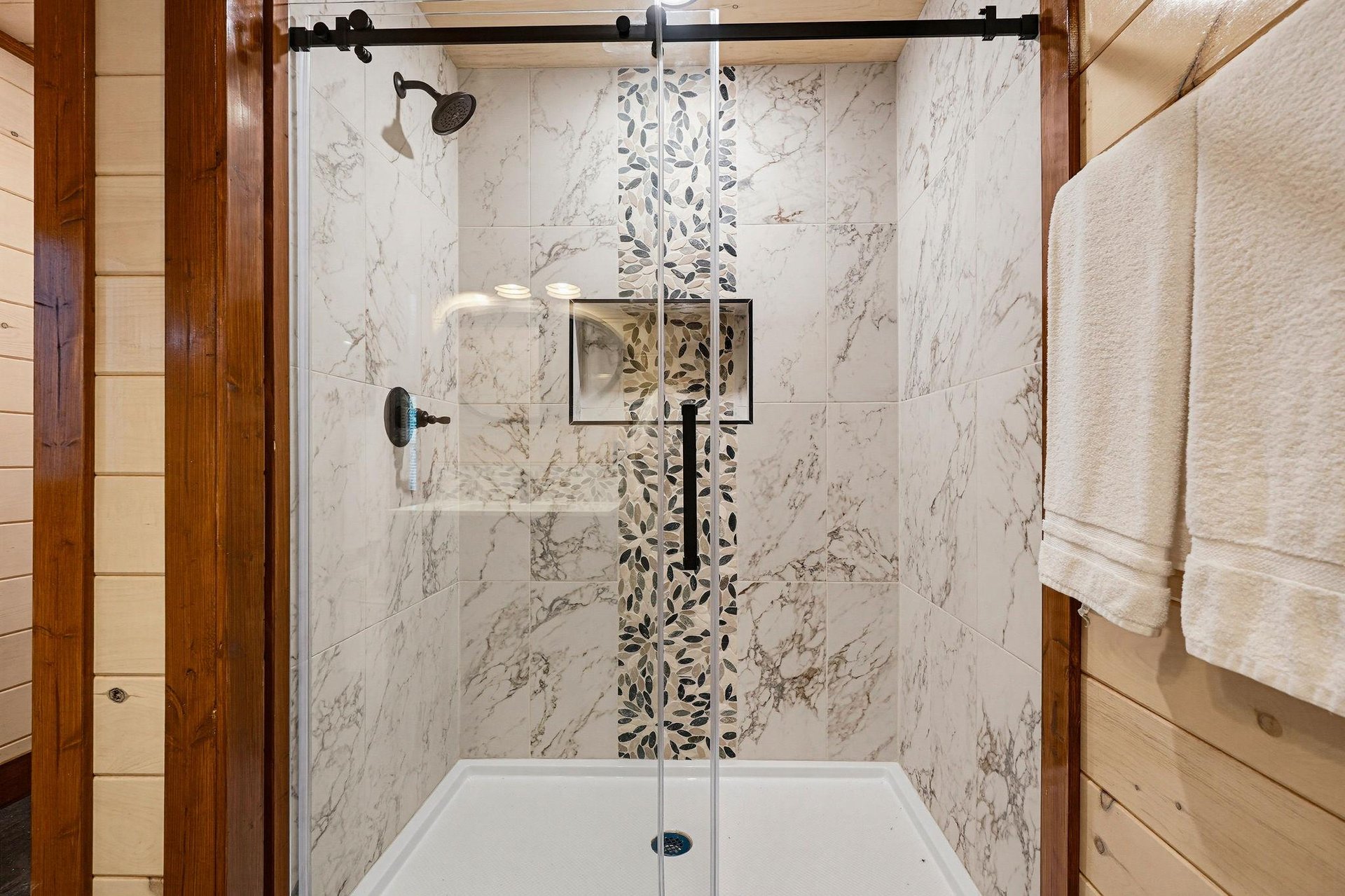Step into a serene, spalike shower with elegant marblelook tile and a rain showerhead—your perfect morning refresh awaits.